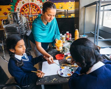 Childcare volunteer with local children in Delhi India with IVHQ