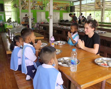 An IVHQer looking after kids to have meal at the Childcare project in Thailand, Hua Hin with IVHQ